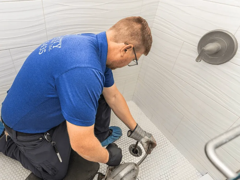 Tech clearing a shower drain