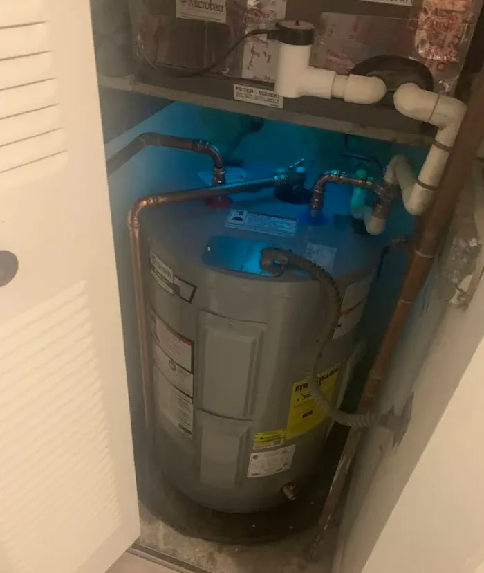 Technician clearing a shower drain with a cable machine